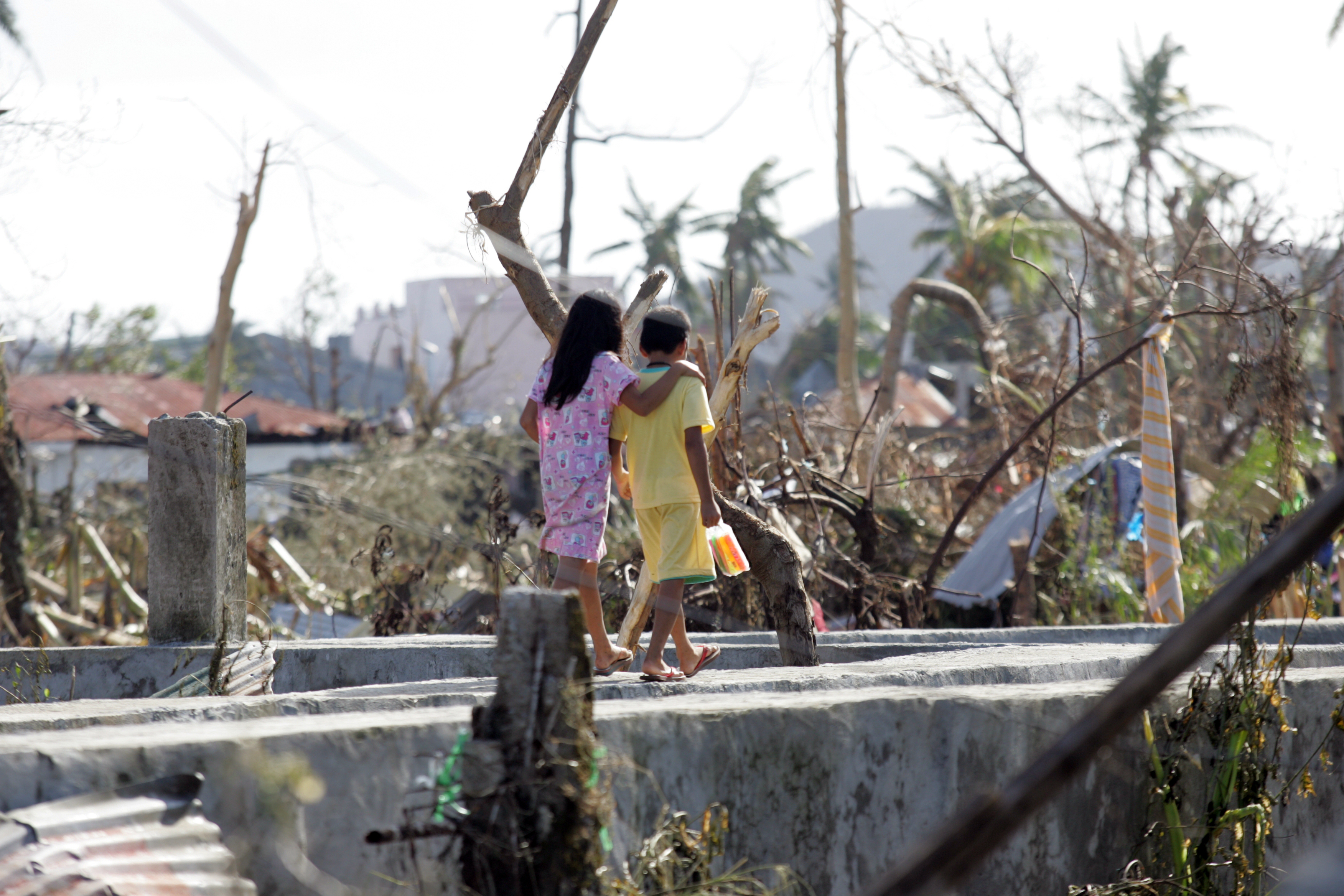 필리핀 레이테 타클로반 시에서 어린이들이 건물 잔해 사이로 걸어가고 있다.  슈퍼태풍 하이옌의 살인적인 위력을 피할 수 있었던 어린이들도 태풍의 여파에서 살아남기 위해 여전히 긴급한 도움이 필요하다.  